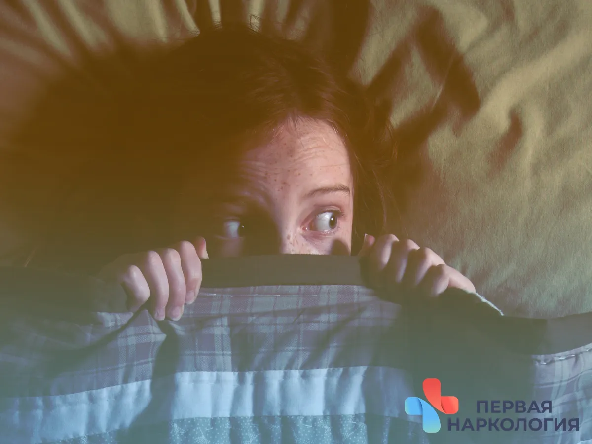 Девушка прячется под одеялом